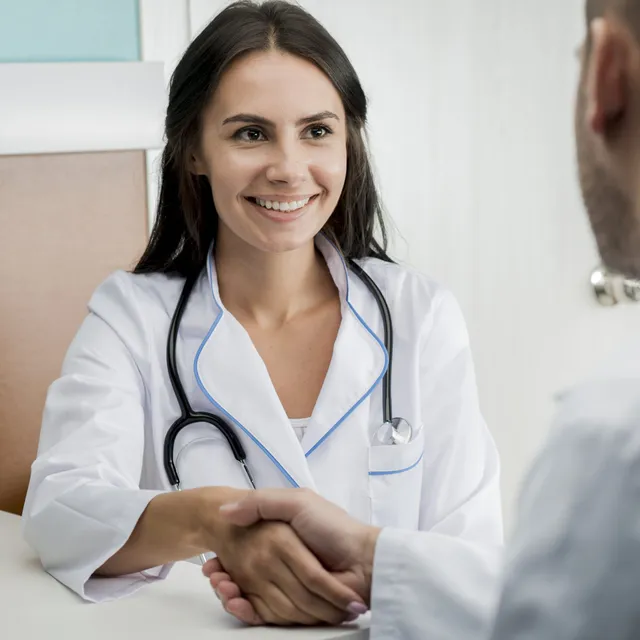A friendly medical professional shaking hands with a patient